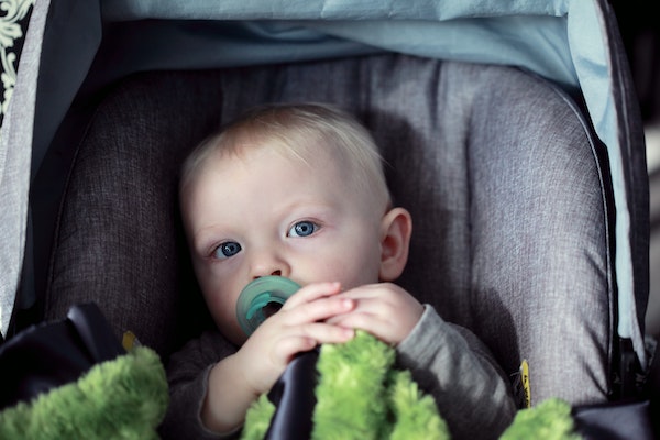bebé en carrito con manta verde